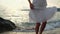 Young woman in white dress walking on beach