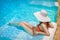 Young woman in white hat resting in pool