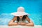 Young woman in white hat resting in pool