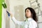 Young woman in white shirt upset with a green color of a painted wall