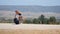 Young woman in white shorts goes alone along the road with the suitcase