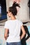 Young woman in white t shirt back shot with dreadlocks hairstyle sunglasses and outdoor in city  spring summer  day