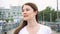 Young woman in white t-shirt walking on pier alone. Wind from sea blowing female hair in slow motion