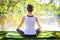 Young woman in white top practicing yoga in beautiful nature.