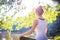 Young woman in white top practicing yoga in beautiful nature.