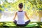 Young woman in white top practicing yoga in beautiful nature. Meditation in morning sunny day