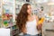 Young woman who came to the pharmacy chooses a hair care remedy