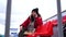 Young woman in winter clothes plays chess, sitting on stadium bleachers alone. Female in black cap with chess on sports