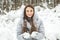 Young woman winter portrait. Winter woman Blowing Snow in forest