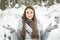 Young woman winter portrait. Winter woman Blowing Snow in forest