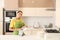 Young woman wiping clean plate in kitchen