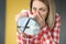 Young woman wiping her nose with tissue in front of mirror