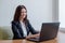 Young woman working behind laptop at office