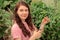 Young woman working in the garden, pinching, side-shoot removal or topping of tomato spring in greenhouse. Growing food concept