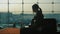 Young woman working with laptop in airport terminal. Waiting for my flight. Silhouette against the background of a large