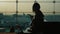 Young woman working with laptop in airport terminal. Waiting for my flight. Silhouette against the background of a large