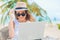 Young woman working in laptop on the beach. Freelance work