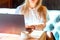 Young woman working with a laptop. Female freelancer connecting to internet via computer. Blogger or journalist writing