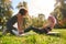 Young woman working out with personal trainer in park