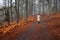 Young woman in worm clothing walking in the forest in winter. Troodos mountain Cyprus