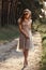 Young woman in wreath walking in forest barefoot