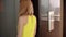 Young woman in yellow dress waiting for elevator arriving. Entering the elevator doors are closing