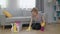 Young woman in yellow gloves with cloth cleaning floor at home in living room