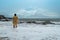 Young woman in yellow rain coat on the beach in heavy rain in Bali