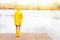 Young woman in yellow raincoat and rubber boots