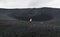 Young woman in yellow raincoat standing in the crater of Hverfjall volcano in Myvatn area, Iceland