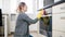 Young woman in yellow rubber gloves washing oven glass door