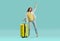 Young woman with yellow suitcase is very happy and excited about her summer holiday