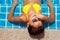 Young woman in a yellow swimsuit laying down in a swimming pool