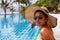 Young woman in a yellow swimsuit seating down in a swimming pool