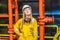 Young woman in a yellow work uniform, glasses and helmet in industrial environment,oil Platform or liquefied gas plant