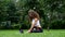 Young woman yoga in the park working on a laptop