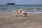 Young woman yoga on sand beach. Tropical seaside vacation activity. Young girl fitness and stretch.