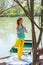 Young woman in yoga tree posture by the lake and cherry  tree full body shot