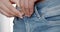 The young woman zips her jeans at the waist. Extreme close-up view