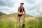 Young women active trail running across a meadow on a grassy trail high in the mountains in the afternoon with trekking pole