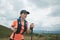 Young women active trail running across a meadow on a grassy trail high in the mountains in the afternoon with trekking pole