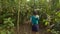 Young women with a baby walks through a jungle