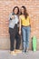 Young women couple making a selfie. Behind brick wall. Positive emotion and tolerance concept