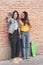 Young women couple making a selfie. Behind brick wall. Positive emotion and tolerance concept