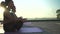 Young women group meditating at yoga class on sunrise outdoors.