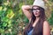 Young women holding hat wearing glasses in nature outside