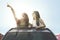 Young women looking something on car sunroof