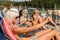 Young women lying on deckchair applying sunscreen