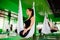 Young women making antigravity yoga exercises with a group of people. aero fly fitness trainer workout. white hammocks.