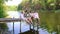 Young women in national Ukrainian clothes on pontoon bridge over river